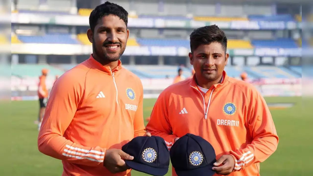 dhruv jurel and sarfarz khan holdin indian team cap wering orange jersey