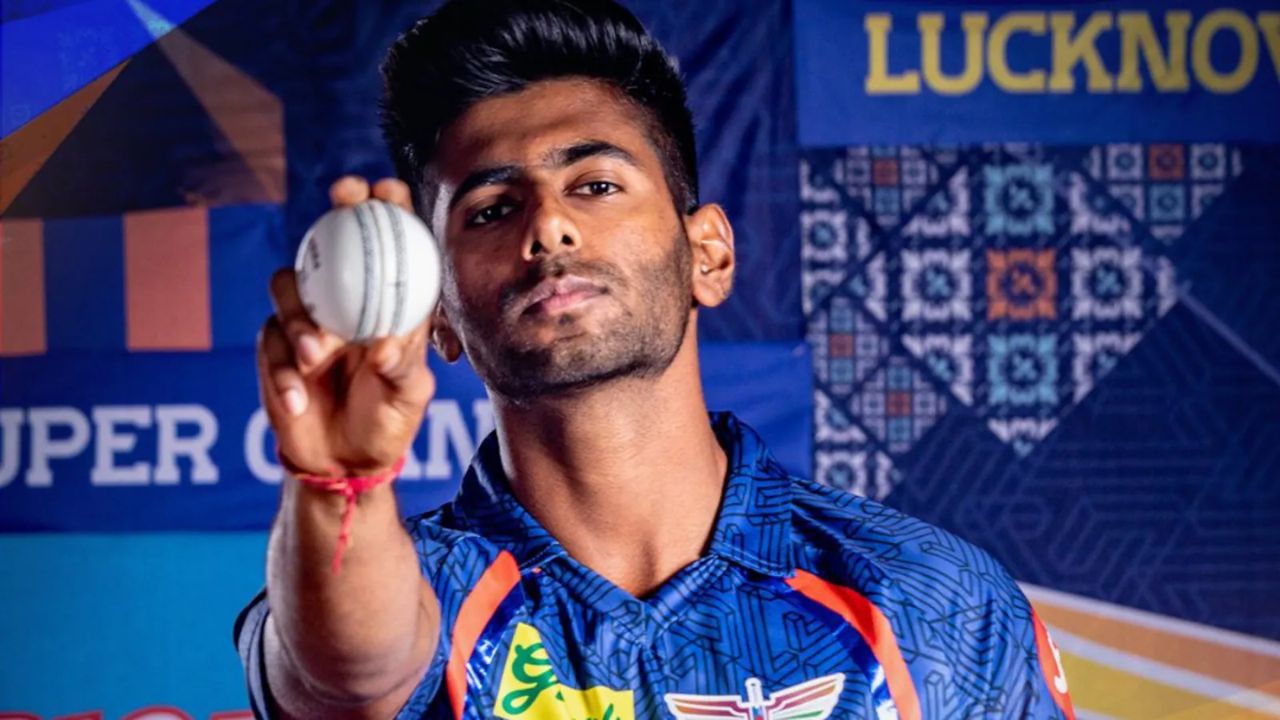 mayank in lsg jersey holding a bow in blue written text background